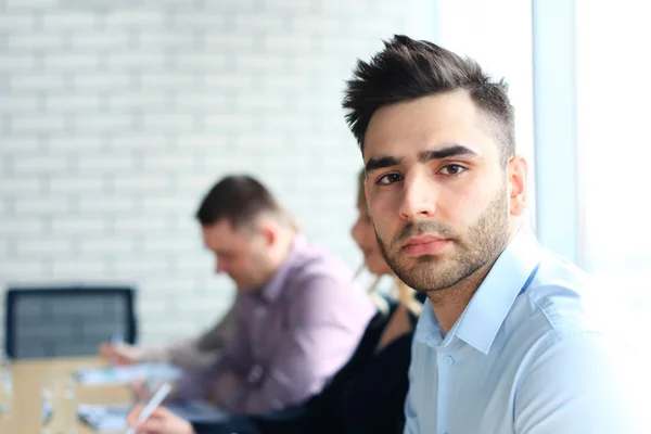 Empresario con colegas en segundo plano — Foto de Stock