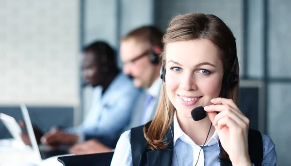 Portret van call center werknemer vergezeld door haar team — Stockfoto