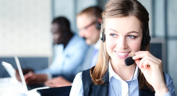 Portret van call center werknemer vergezeld door haar team — Stockfoto