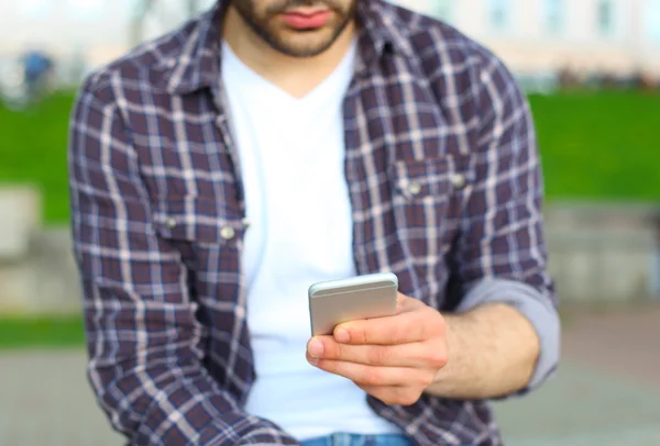 Man använder sin mobiltelefon utomhus — Stockfoto