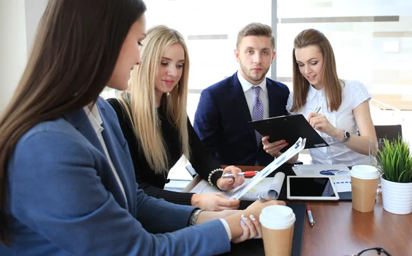 Feliz hombre de negocios inteligente con compañeros de equipo discutiendo en segundo plano —  Fotos de Stock