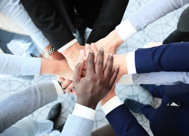 Bir grup iş adamı el ele tutuşuyor.