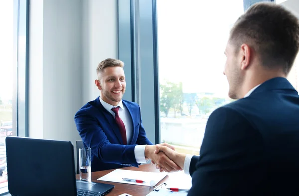 Empresários apertando as mãos, terminando uma reunião — Fotografia de Stock