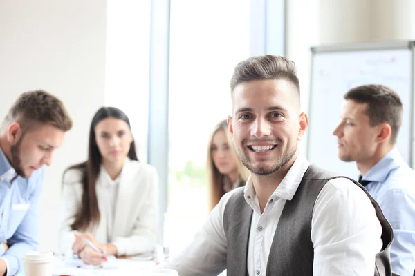 Empresario con colegas en segundo plano en la oficina — Foto de Stock