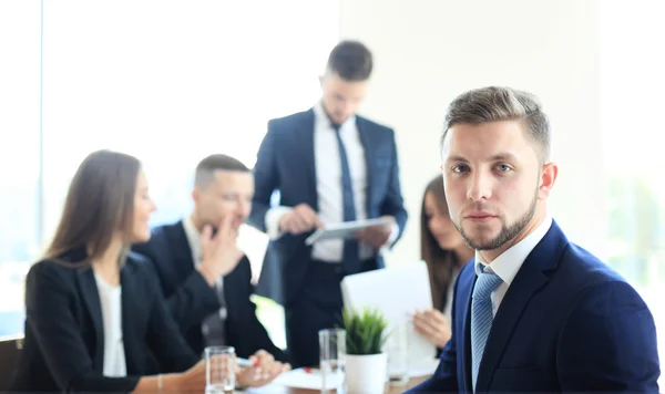 Businessman with colleagues in the background in office — Stock Photo, Image
