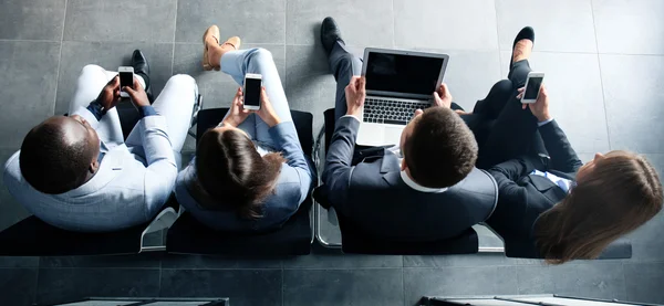 Grupo de jovens empresários atraentes sentados nas cadeiras usando um laptop — Fotografia de Stock