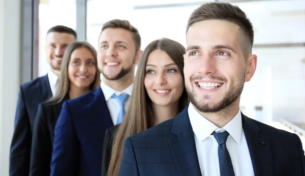 Feliz equipo de negocios sonriente de pie en una fila en la oficina —  Fotos de Stock