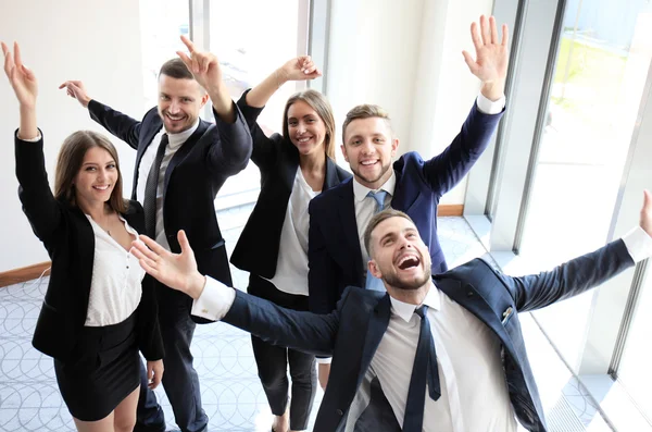 Feliz equipo de negocios celebrando la victoria en el cargo — Foto de Stock