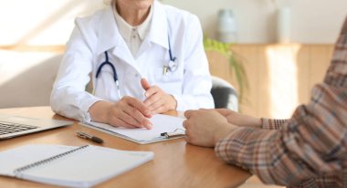 Ofisteki hastaya danışmanlık yapan orta yaşlı kadın doktor.