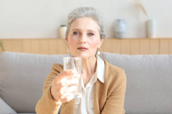 Ελκυστική Μεσήλικη Γυναίκα Που Κρατάει Ένα Ποτήρι Νερό Και Κοιτάζει — Φωτογραφία Αρχείου