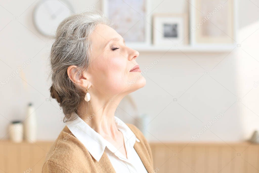 Attractive middle aged woman relaxing in sofa at home