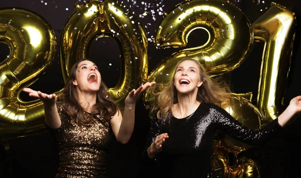 Happy gorgeous girls in stylish sexy party dresses holding gold 2021 balloons, having fun at New Year Eve Party. — стоковое фото