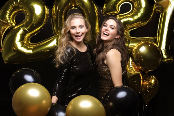 Happy gorgeous girls in stylish sexy party dresses holding gold 2021 balloons, having fun at New Year Eve Party. — стоковое фото