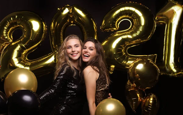 Happy gorgeous girls in stylish sexy party dresses holding gold 2021 balloons, having fun at New Years Eve Party. — Stock Photo, Image