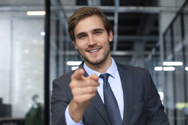 Güvenilir işadamı kameraya bakıyor şirket stratejisi ve iş planı hakkında konuşuyor, kurumsal başarıyı anlatıyor.
