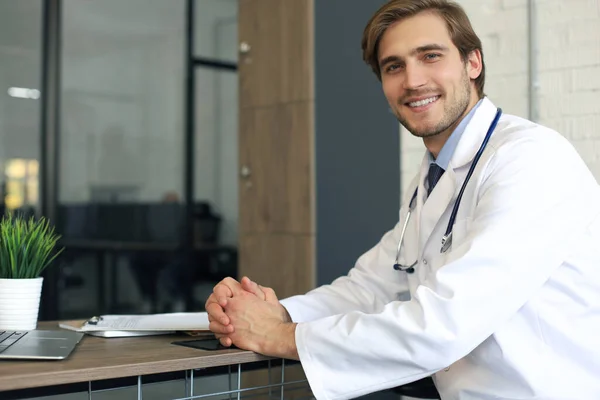 Guapo Amable Joven Médico Pasillo Del Hospital Mirando Cámara Sonriendo — Foto de Stock