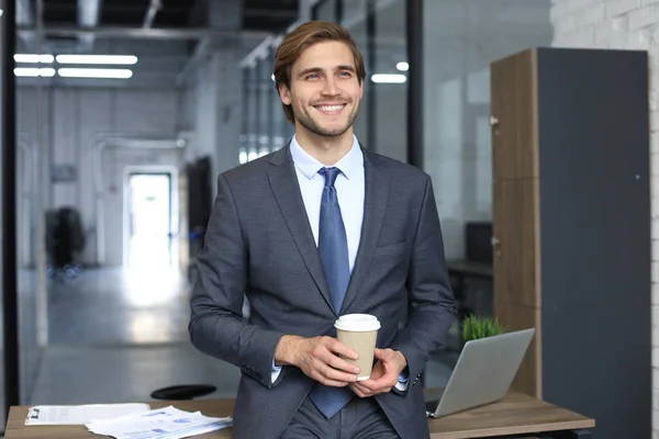 オフィス環境で笑顔の若いハンサムなビジネスマン — ストック写真