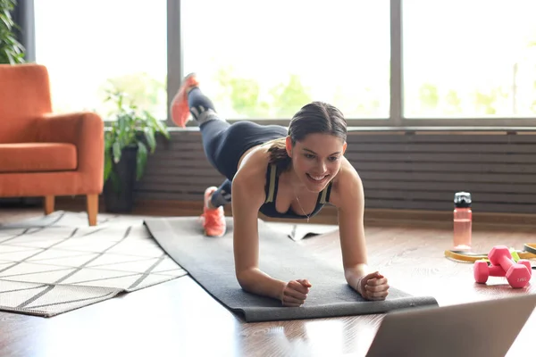 Фитнес Женщина Делает Упражнения Доске Смотрит Онлайн Уроки Ноутбуке Тренируется — стоковое фото