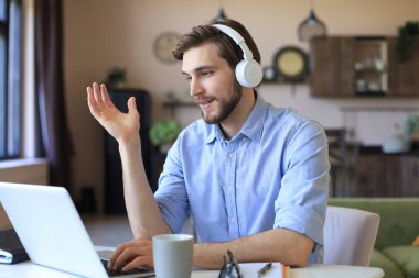Kulaklık takan kendine güvenen bir adam konuşuyor ve iş kıyafetleri eğitimi izliyor, konferans dinliyor.