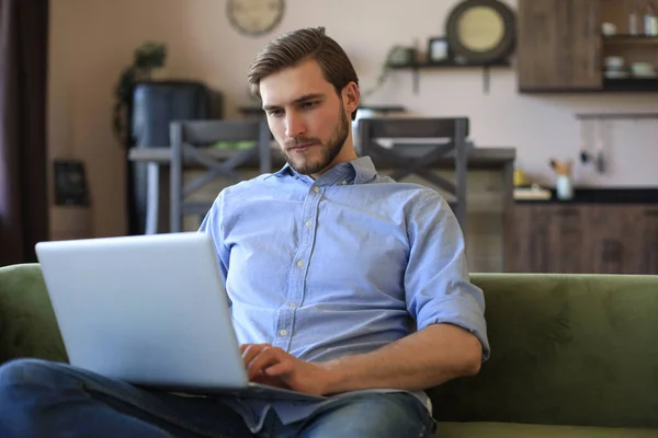 Koncentrerad Ung Frilansare Affärsman Sitter Soffan Med Bärbar Dator Arbetar — Stockfoto