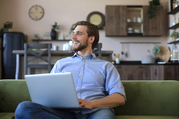 Ευτυχισμένος Νεαρός Ελεύθερος Επαγγελματίας Επιχειρηματίας Κάθεται Στον Καναπέ Φορητό Υπολογιστή — Φωτογραφία Αρχείου