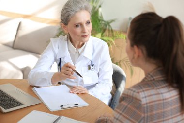 Ofisteki hastaya danışmanlık yapan orta yaşlı kadın doktor.