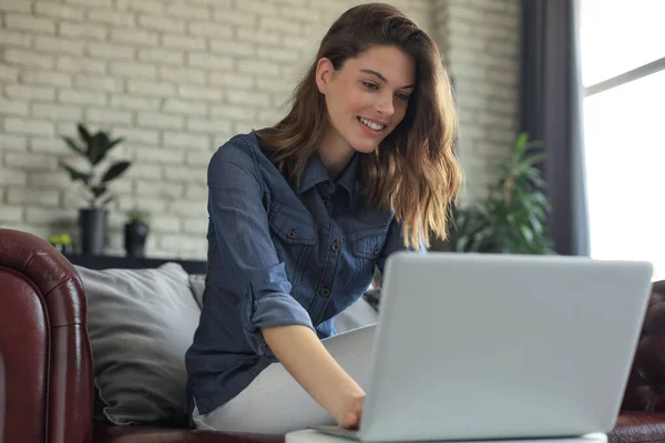 Sorrindo Jovem Mulher Sentada Sofá Com Computador Portátil Conversando Com — Fotografia de Stock