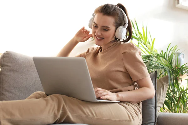 Smiling Young Woman Headphones Laptop Sofa — Stock Photo, Image