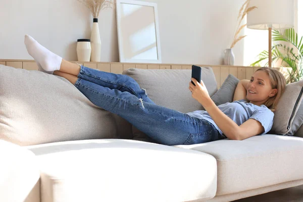 Menina Bonita Usando Seu Smartphone Sofá Casa Sala Estar — Fotografia de Stock