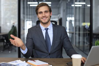 Güvenilir işadamı kameraya bakıyor şirket stratejisi ve iş planı hakkında konuşuyor, kurumsal başarıyı anlatıyor.