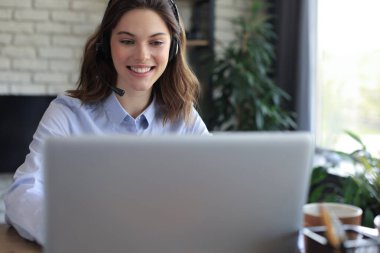 Kulaklıklı ve gülümseyen kadın müşteri destek operatörü