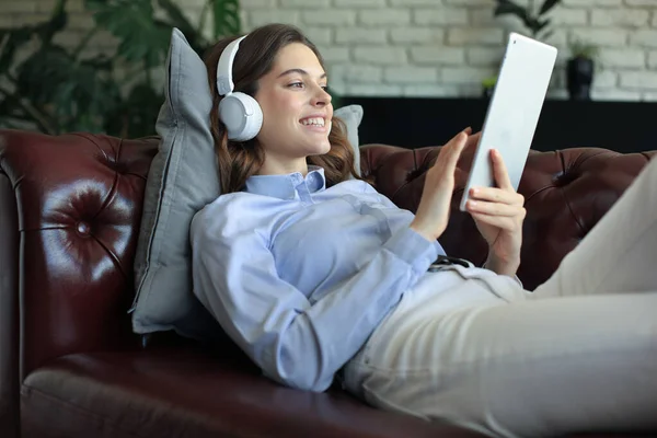 Smiling Young Woman Headphones Digital Tablet Sofa — Stock Photo, Image