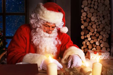 Mutlu Noel Baba 'nın portresi Noel ağacının yanındaki odasında oturuyor ve Noel mektuplarına cevap veriyor.