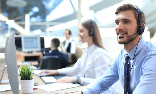 Line of call centre employees working on computers.