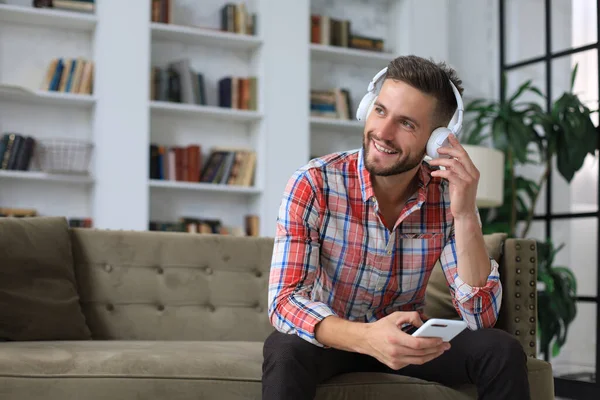 Attraktiv Ung Man Koppla Soffa Hemma Och Använda Mobiltelefon För — Stockfoto