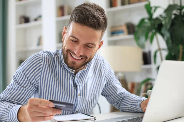 Hombre Sonriente Sentado Oficina Paga Con Tarjeta Crédito Con Computadora — Foto de Stock