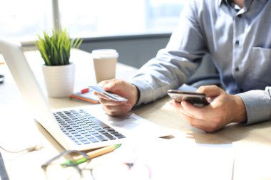 Mpderm adamı kredi kartı ve cep telefonunu online ödeme için kullanıyor. Mobil alışveriş kavramı