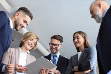 Bir grup iş ortağı ofiste fikir ve planlama işini tartışıyor.