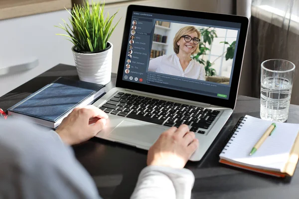 Frau bei einer Videokonferenz mit Kollegen am Tisch. Multiethnisches Geschäftsteam arbeitet von zu Hause aus mit Laptop — Stockfoto