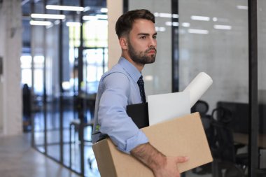 Üzgün işçi ofis malzemelerini yanında götürüyor.