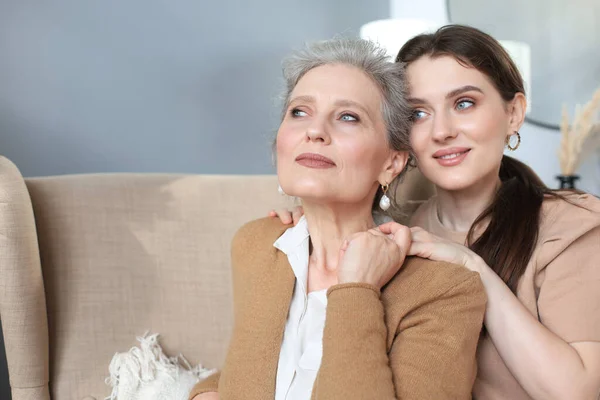 Äldre Mellanmamma Sitter Stol Och Hennes Dotter Kramas Tittar Kameran — Stockfoto