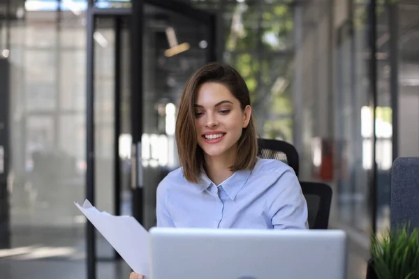매력적 사업가가 사무실에서 서류를 확인하고 노트북으로 일하는 — 스톡 사진