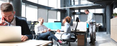 Bir grup mutlu ilerici iş adamı yaratıcı ofiste birlikte çalışıyor..