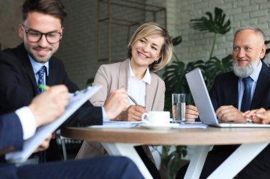 Bir grup iş ortağı ofiste fikir ve planlama işini tartışıyor.