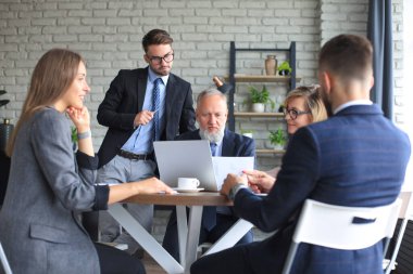 Bir grup iş ortağı ofiste fikir ve planlama işini tartışıyor.