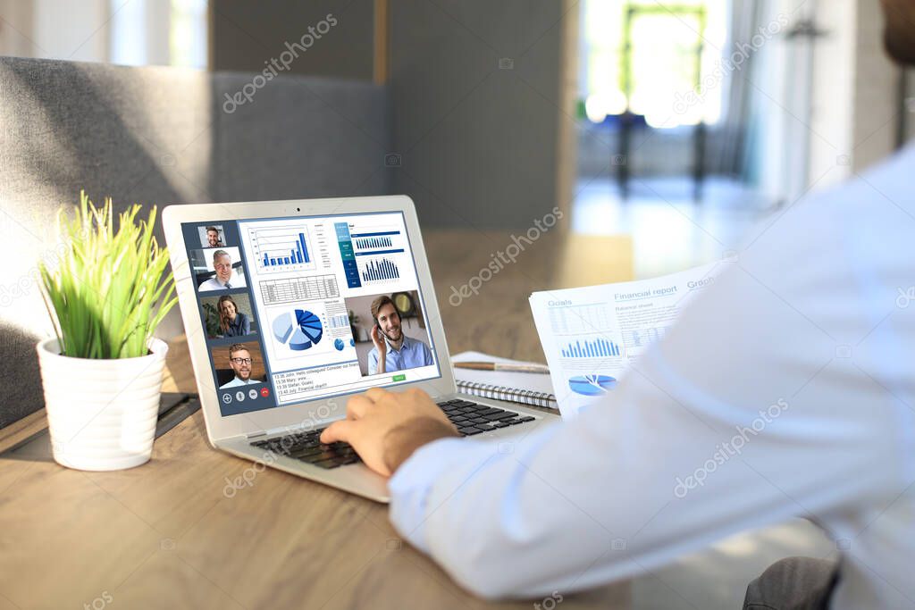 Businessman talking to his colleagues in video conference. Business team working from office using computer PC, discussing financial report of their company.