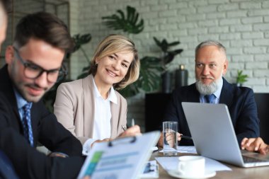 Bir grup iş ortağı ofiste fikir ve planlama işini tartışıyor.