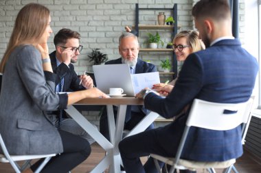 Bir grup iş ortağı ofiste fikir ve planlama işini tartışıyor.