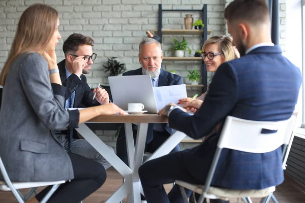 Bir grup iş ortağı ofiste fikir ve planlama işini tartışıyor.