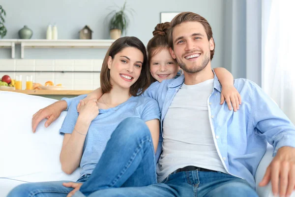 Padres Jóvenes Amistosos Positivos Con Una Hijita Sonriente Sentada Sofá —  Fotos de Stock